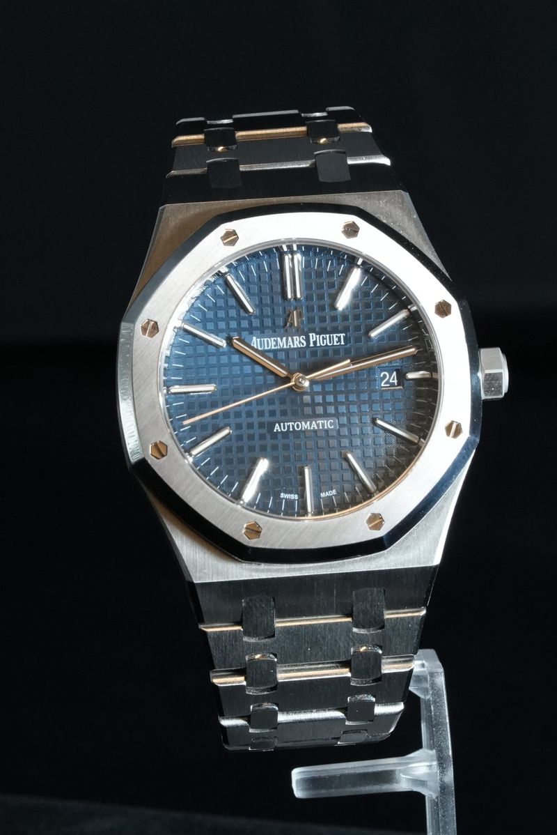 Two-tone Audemars Piguet Royal Oak with a blue tapisserie dial on a clear stand